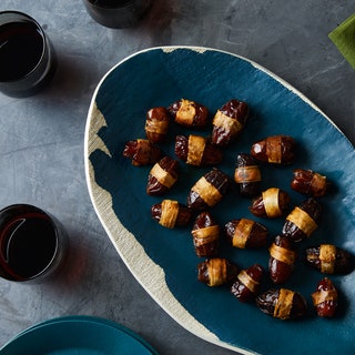 Medjool dates wrapped with parsnip on a blue plate.